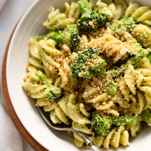 Broccoli pesto pasta in bowl up close with fork.