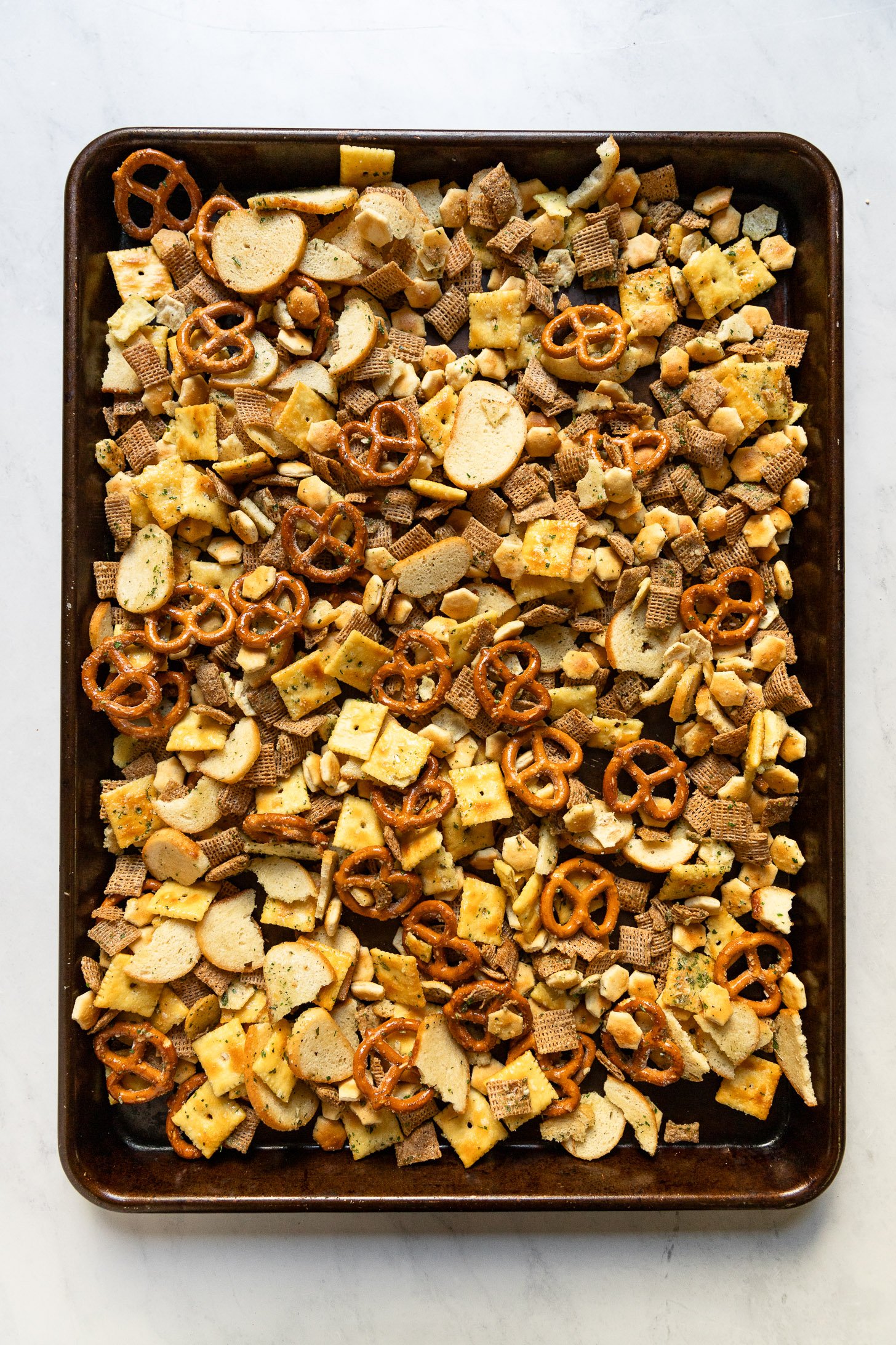 Sheet pan with tossed and baked ranch snack mix.