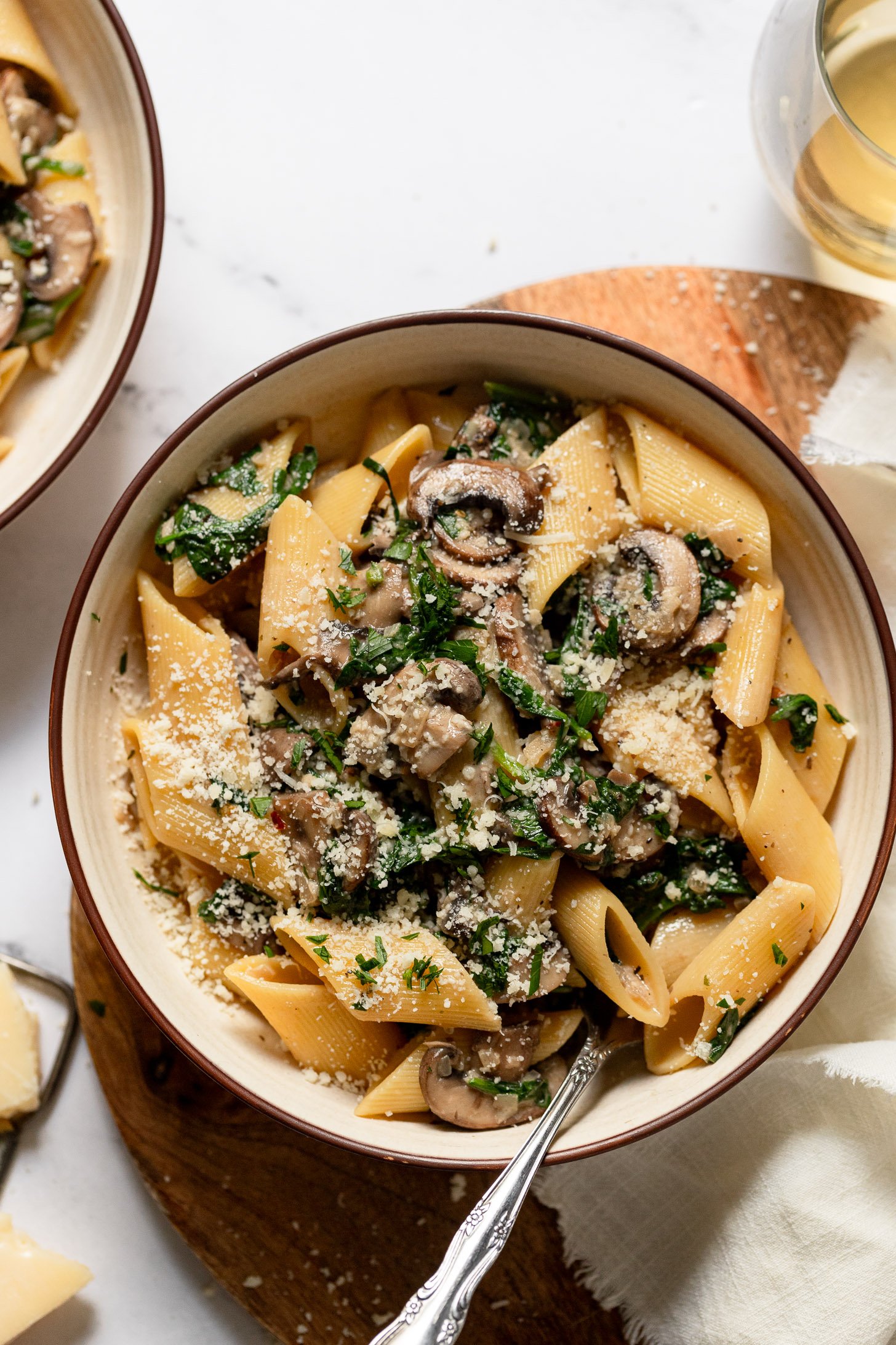 Two bowls of mushroom spinach pasta with penne.