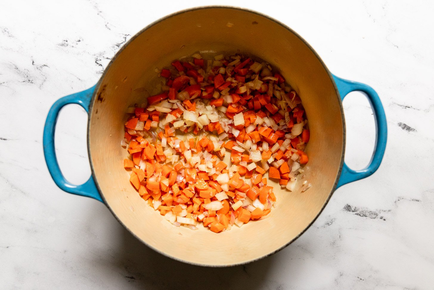 Shallot and diced carrot in Dutch oven.