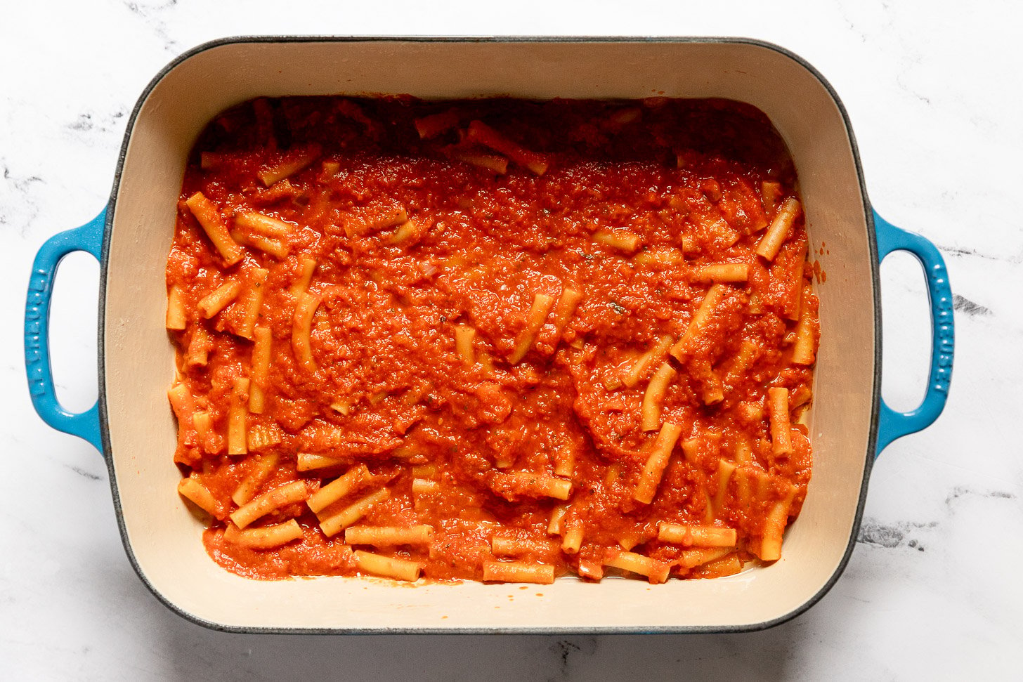 Pasta and sauce in casserole pan.