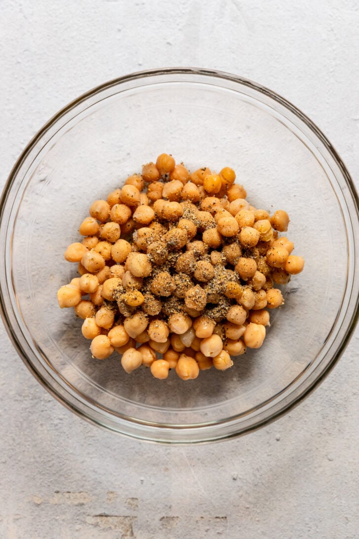 Bowl with chickpeas and seasoning on top.