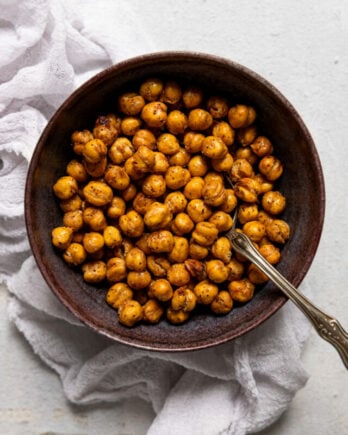 Bowl of air fryer chickpeas with spoon ned to linen.