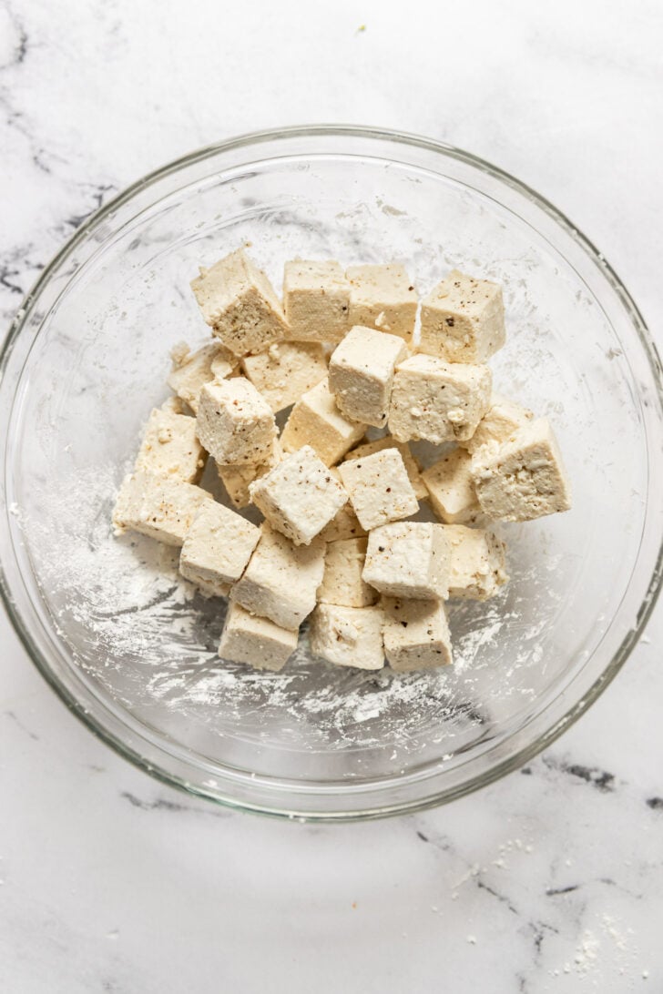 Diced tofu in bowl coated with cornstarch.