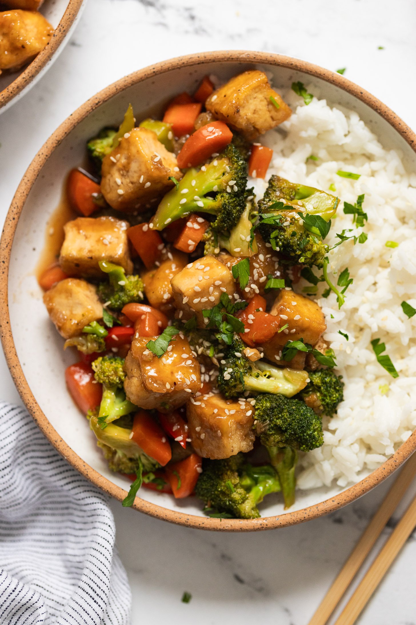 Bowl of stir fry with vegetables and tofu over rice.