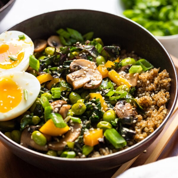Quinoa breakfast bowl topped with mushroom veggie mixture and soft boiled egg.