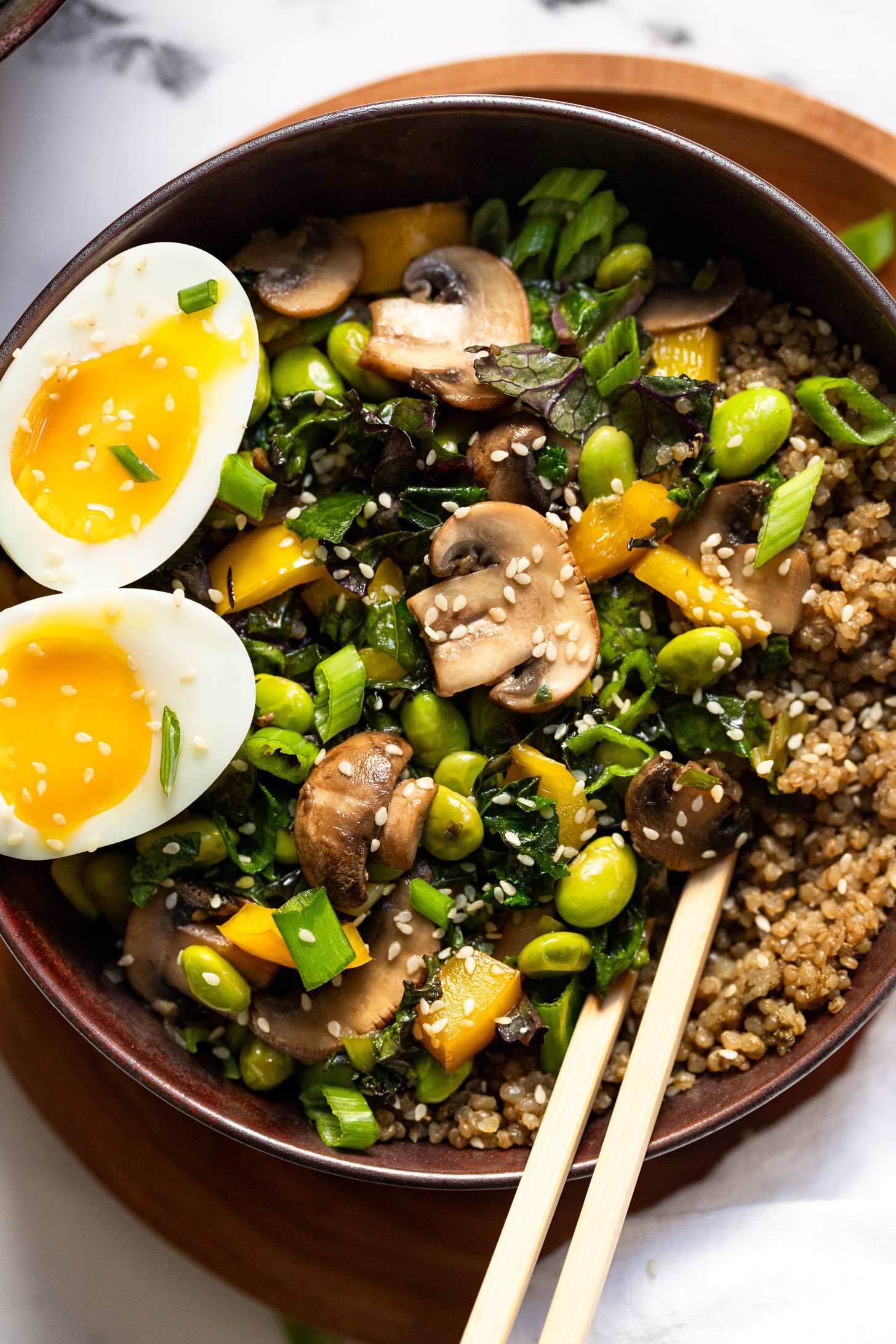 Mushroom and edamame breakfast bowl with egg and chopsticks.