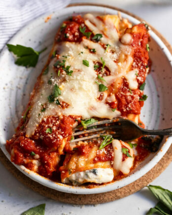 Cheese manicotti on plate with fork.