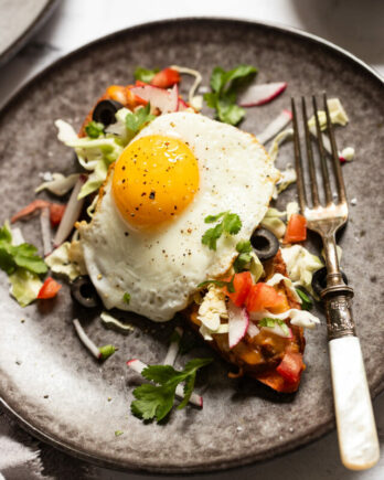 Sweet potato breakfast toast with egg and taco toppings on plate.