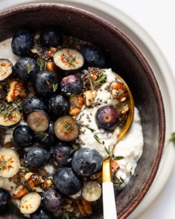 Spoon in bowl with cottage cheese and blueberries.